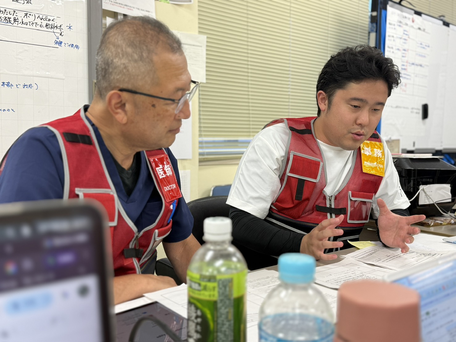 JMAT災害支援活動の現場で医師とともに情報共有を行う様子